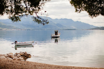 Boat moored in lake against sky