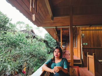 Portrait of young woman sitting on the balcony of the hotel room