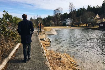 Man walking on pathway by lake