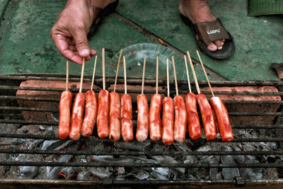 Midsection of man preparing food on barbecue grill