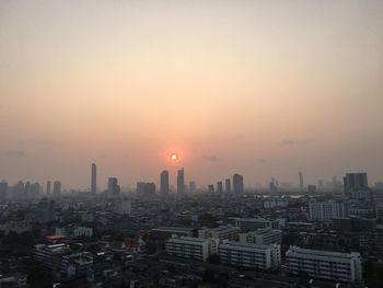 Aerial view of buildings against sky during sunrise