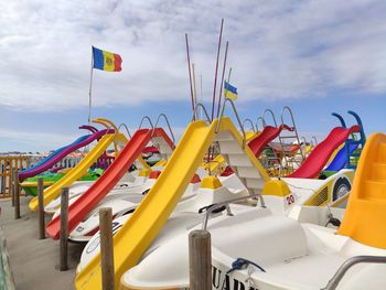 Multi colored chairs at beach against sky