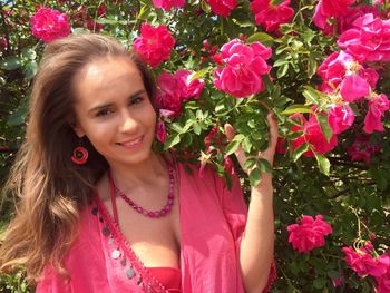 Portrait of smiling young woman with pink flowers