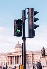 Traffic light with two green man holding hand in hand, with a heart between them. 