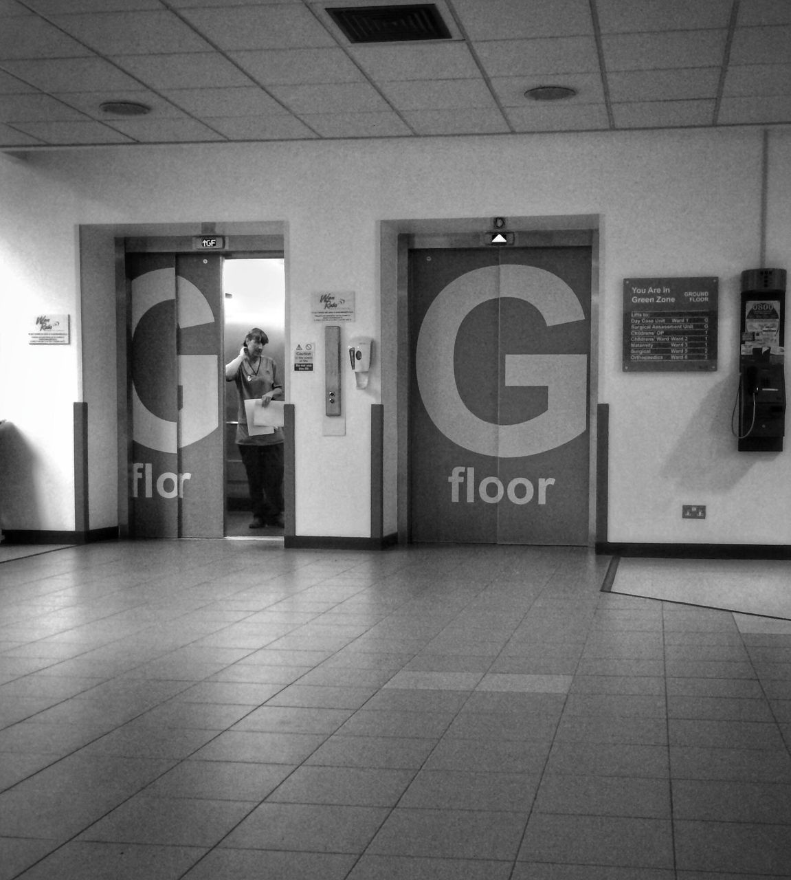 indoors, communication, text, technology, flooring, tiled floor, men, western script, lifestyles, door, reflection, public transportation, tile, railroad station, person, wireless technology, number, non-western script