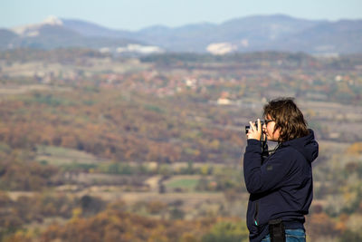 Man photographing against sky