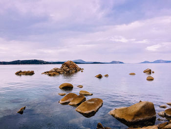 Rocks in sea against sky