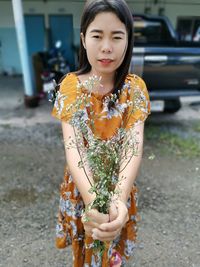 Young woman looking away while standing on street