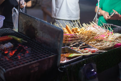 Midsection of man preparing food on barbecue grill