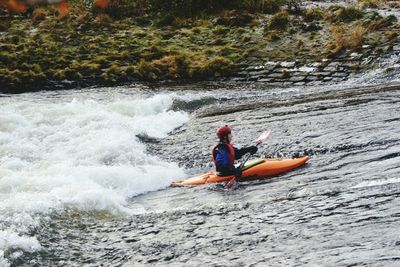 Man surfing on boat in river