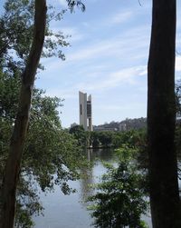 Reflection of trees and buildings in lake against sky