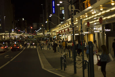 People on illuminated street at night