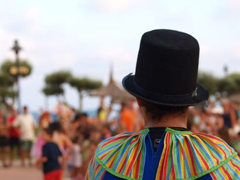 Rear view of street performer standing on walkway