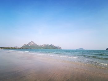 Scenic view of beach against clear blue sky