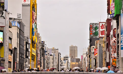 Traffic on road by buildings in city against osaka skyline in japan 