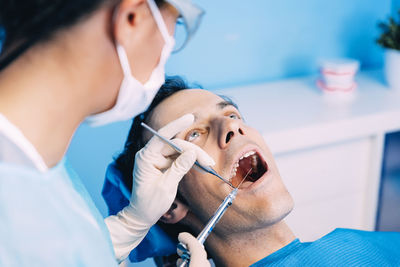 Dentist examining patient in clinic