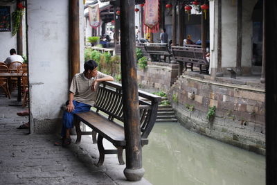 Man sitting on chair in old town