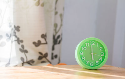 Close-up of clock on table at home