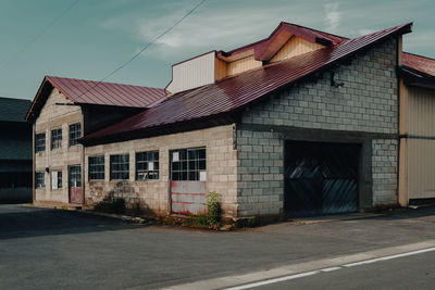 Residential building by road against sky