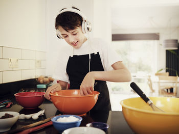 Mid adult woman having food at home