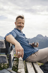Portrait of smiling man sitting outdoors