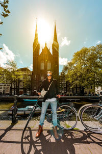 Portrait of man riding bicycle against building