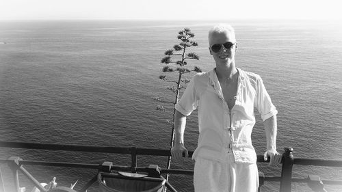 Portrait of man standing by sea against sky