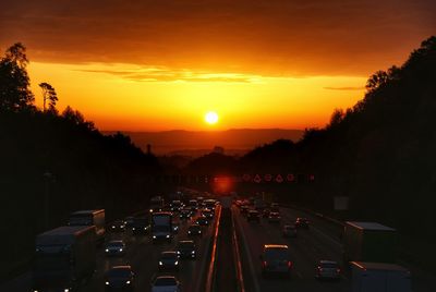 Traffic on road in city during sunset