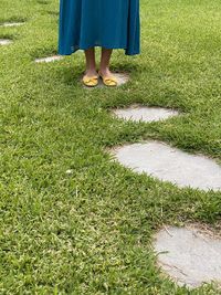 Low section of woman standing on field