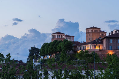 Buildings in city against cloudy sky