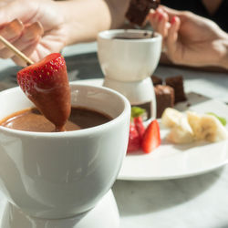 Cropped hands having food at table