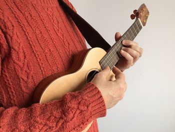 Midsection of woman playing ukelele