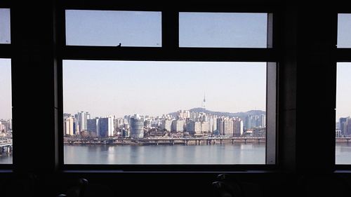 City buildings against sky seen through window