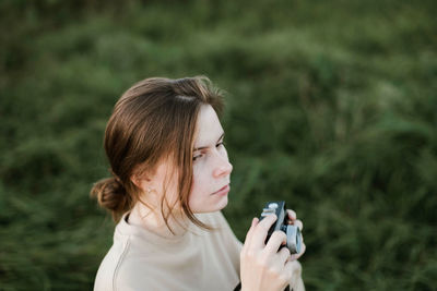 Portrait of woman photographing outdoors