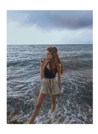 Young woman standing in sea against sky