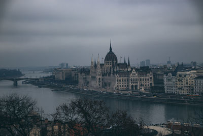 River amidst buildings against sky in city