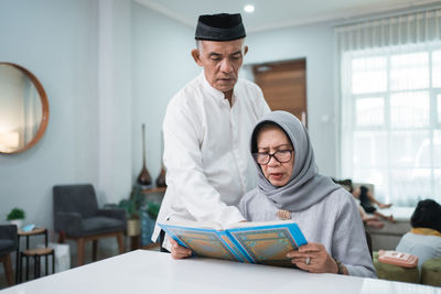 Young man reading book at home