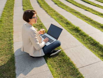 Businesswoman using laptop at office park