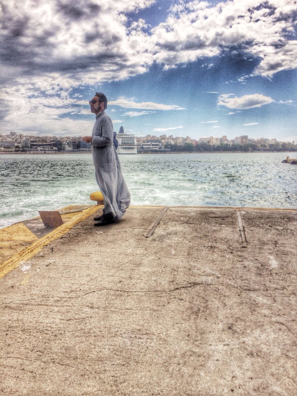 full length, lifestyles, water, casual clothing, sky, person, leisure activity, young adult, cloud - sky, standing, beach, young men, sea, looking at camera, nature, vacations, portrait, shore