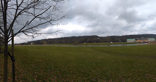 Scenic view of grassy field against cloudy sky