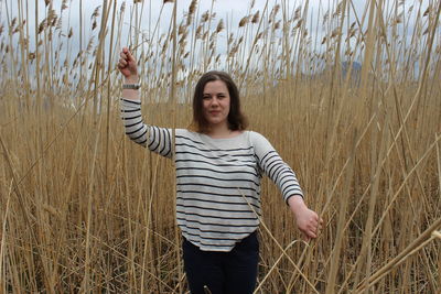 Portrait of a young girl in an outdoor field against a backdrop of wheat or tall grass..