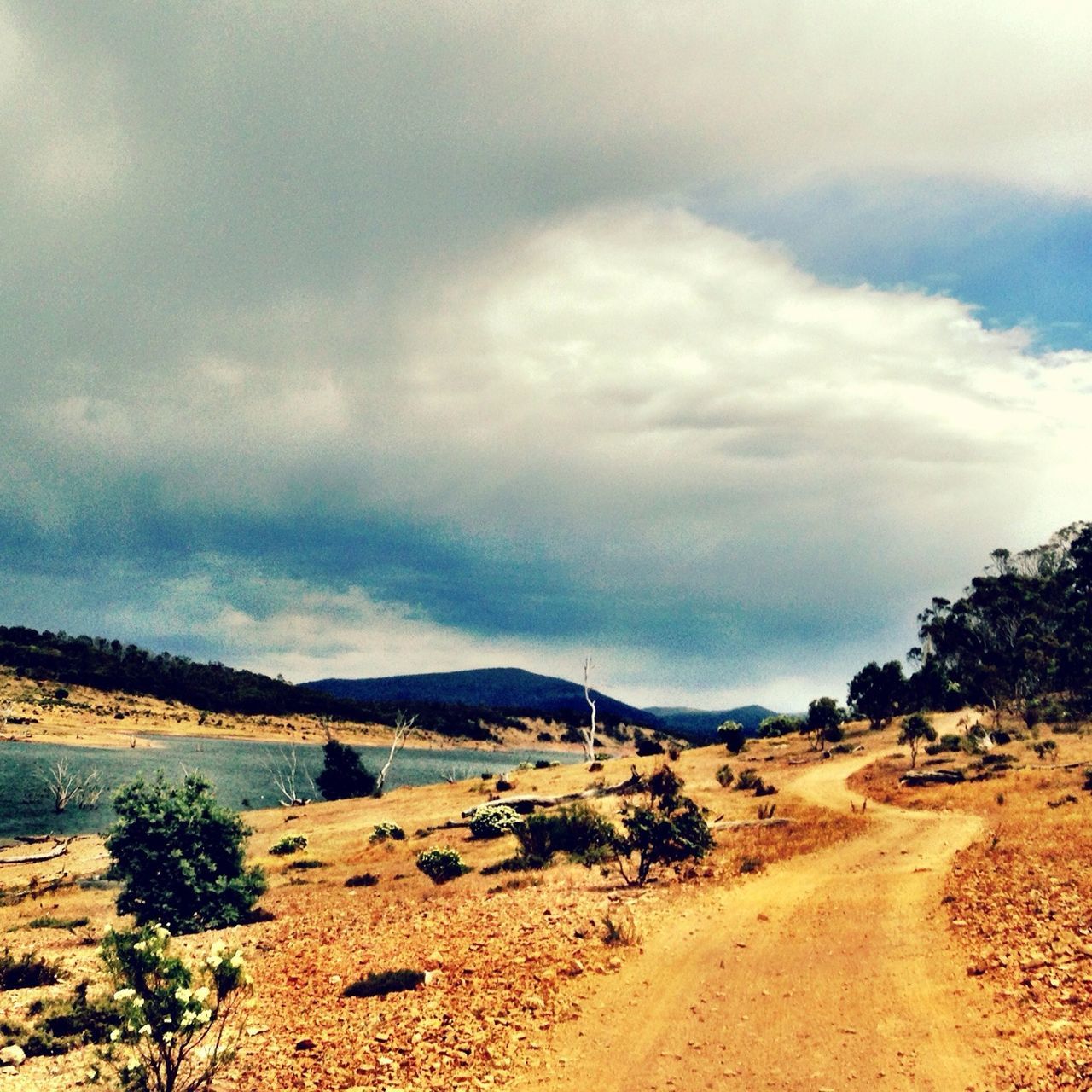 sky, tranquil scene, the way forward, tranquility, sand, road, scenics, cloud - sky, landscape, beauty in nature, nature, dirt road, mountain, cloud, beach, transportation, diminishing perspective, cloudy, water, non-urban scene