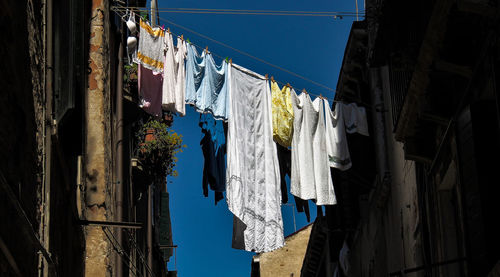 Low angle view of clothes drying against buildings