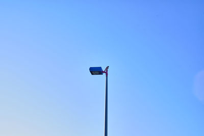 Low angle view of street light against blue sky