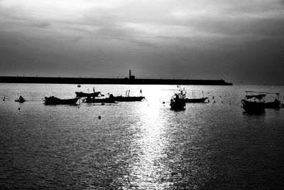 Silhouette sailboats in sea against sky