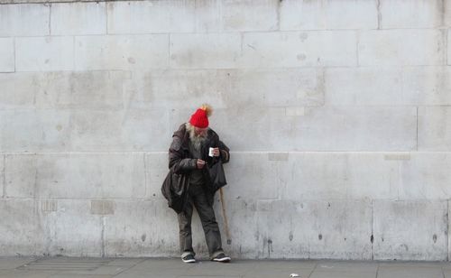 Man and woman standing against wall