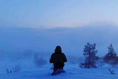 Rear view of man on snow covered field