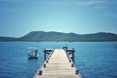 Pier over lake against blue sky