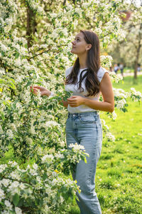 Young woman standing against plants