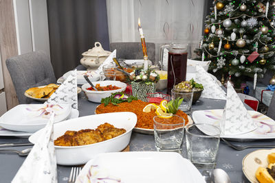 A table set before the supper for christmas in poland, visible baked fish fillets in a carrot salad. 